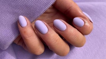 unhas lilás sob fundo da mesma cor.