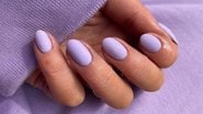 unhas lilás sob fundo da mesma cor.