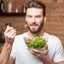homem com bowl de salada em mãos