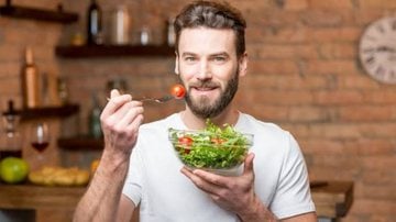 homem com bowl de salada em mãos