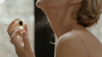 mulher borrifando perfume