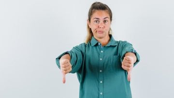 mulher fazendo sinal negativo com as mãos.