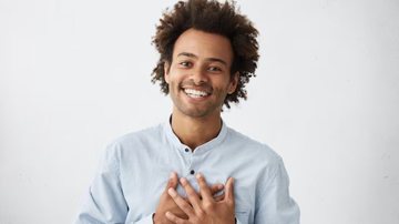 homem com mãos no peito e sorriso no rosto