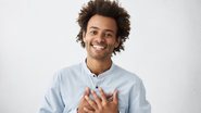 homem com mãos no peito e sorriso no rosto