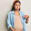 mulher grávida com mãos sob a barriga e expressão triste.