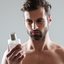 homem segurando frasco de perfume