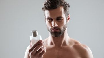 homem segurando frasco de perfume