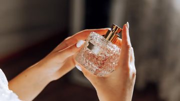 mulher com frasco de perfume em mãos.