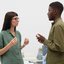 mulher e homem frente a frente, conversando, com expressões neutras.