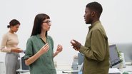 mulher e homem frente a frente, conversando, com expressões neutras.