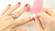 pessoa removendo esmalte das unhas com removedor.