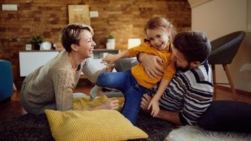 pais e filha rindo e brincando.