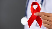médico segurando laço vermelho para a campanha de setembro vermelho