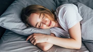 mulher deitada de lado na cama, dormindo serenamente.