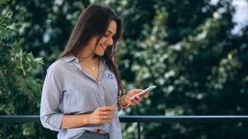Mulher mandando mensagem no celular.