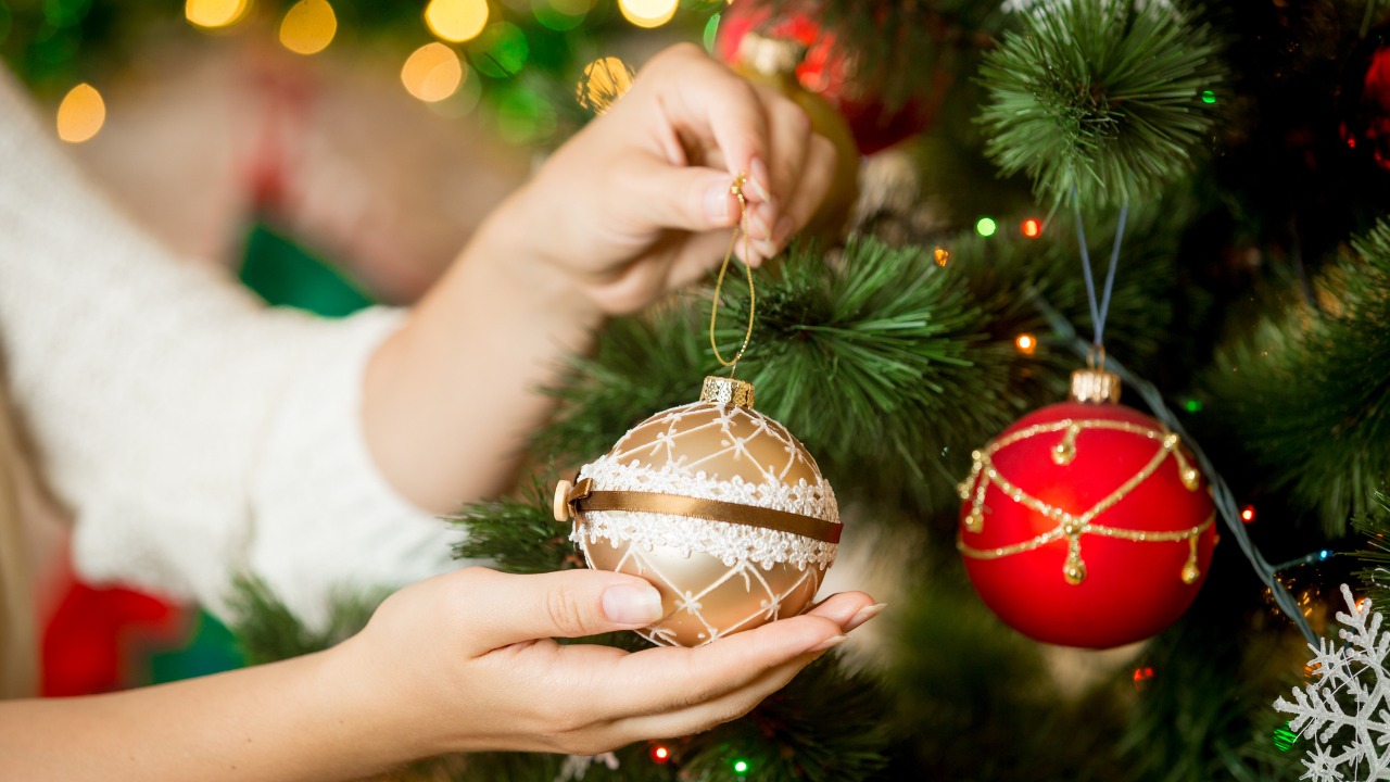 Mulher decorando árvore de Natal