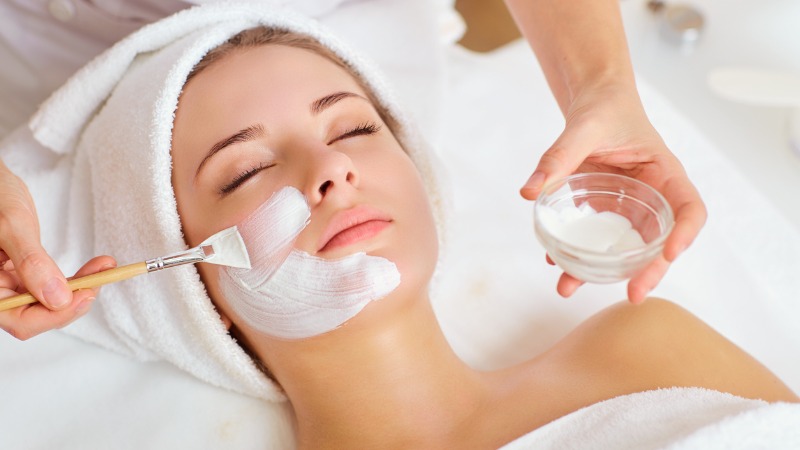 Mulher recebendo máscara facial em spa