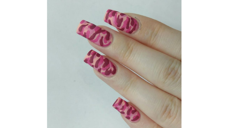 Unhas rosas decoradas com animal print.