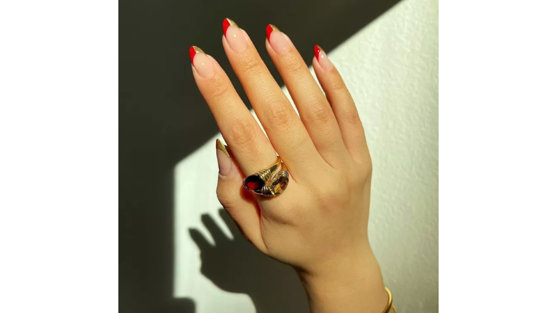 Unhas francesinhas em vermelho e dourado.