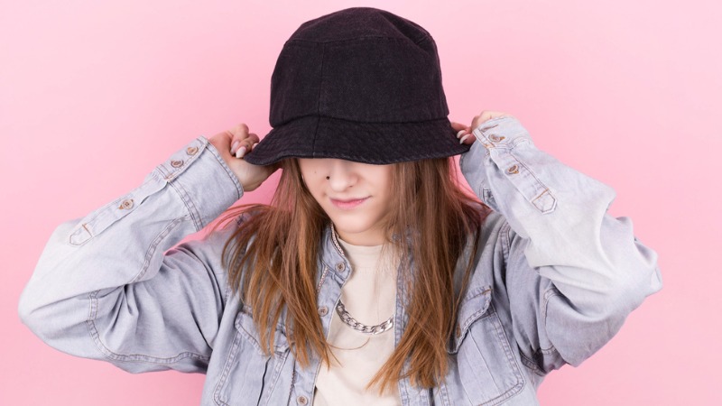 Modelo posando com bucket hat preto.