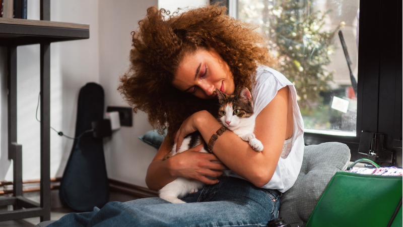 Mulher abraçando e dando carinho para o seu gato;