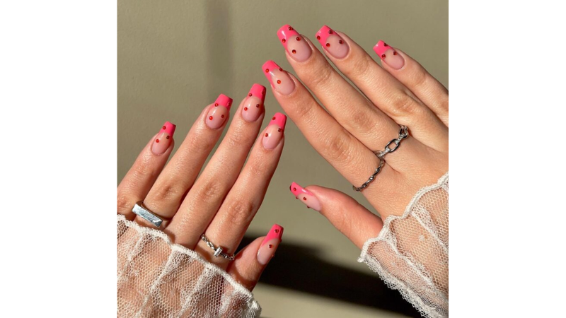 Unhas decoradas com aplicações brilhosas.