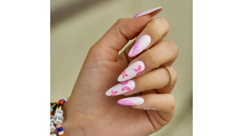 Unhas decoradas em branco e rosa.