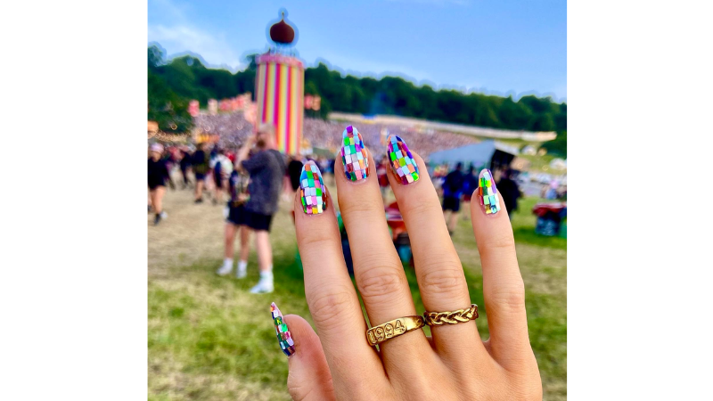 Unhas decoradas para festival com aplicações coloridas.