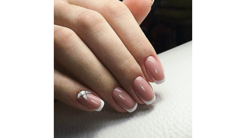 Unhas simples decoradas com aplicações em pedras.