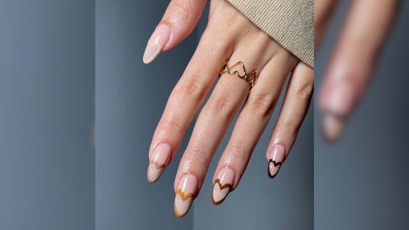 A francesinha é uma nail art clássica e cheia de estilo. Quando combinada com corações e tons marrons amenos, consegue transmitir uma elegância ainda maior.