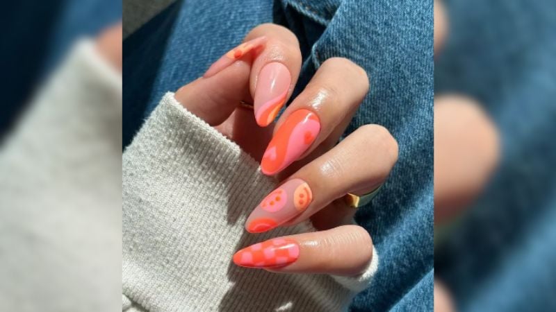 Unhas dopaminas são uma das tendências deste ano. Com adesivos alegres e cores marcantes, este estilo pode muito bem ser construído com esmalte laranja.