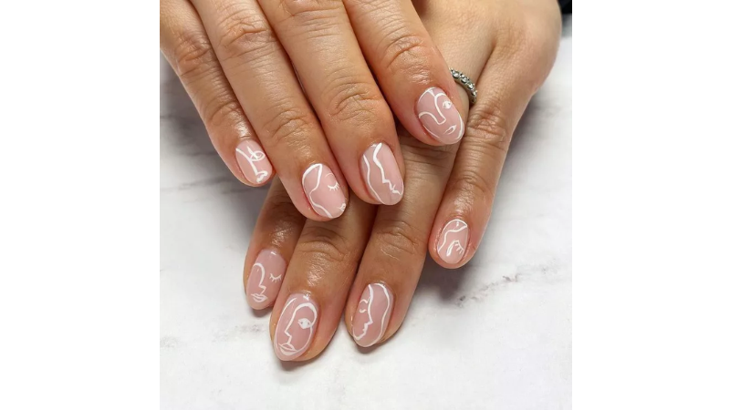 Unhas nude com desenhos artísticos.