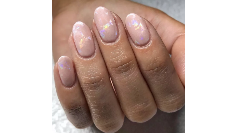 Unhas nude com acabamento perolado.