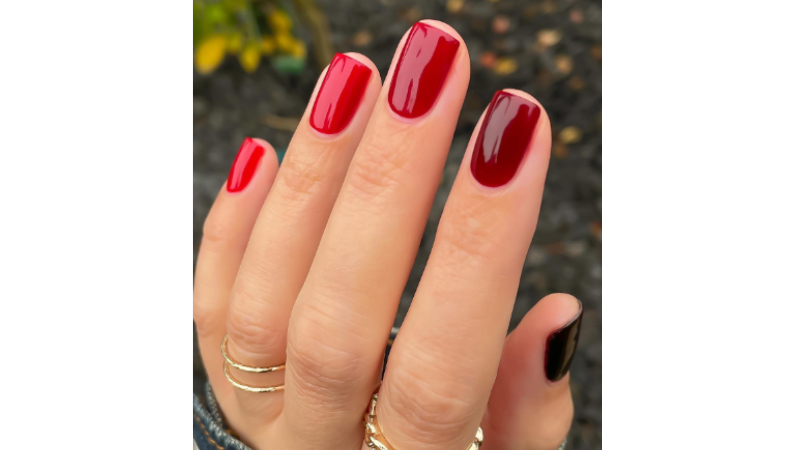 Unhas decoradas em vermelho.