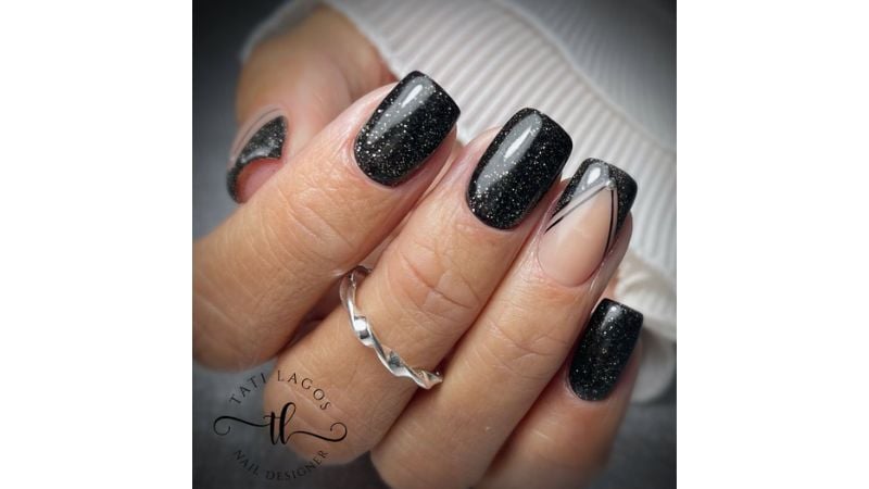 Uma unha destacada em meio a unhas pretas com glittler é uma ótima forma de destacar as mãos!