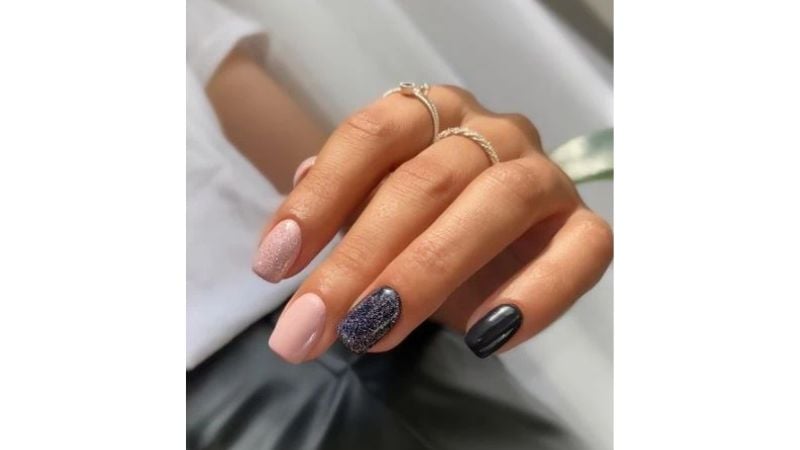 Combinar unhas pretas com glitter com o esmalte nude é uma alternativa diferente e cheia de estilo.