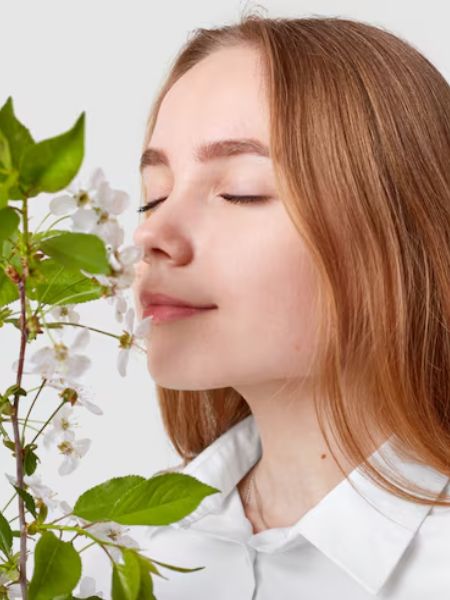 mulher cheirando ramo de flores.