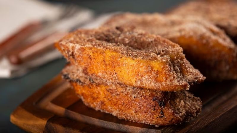 rabanadas empilhadas sob tábua de madeira.