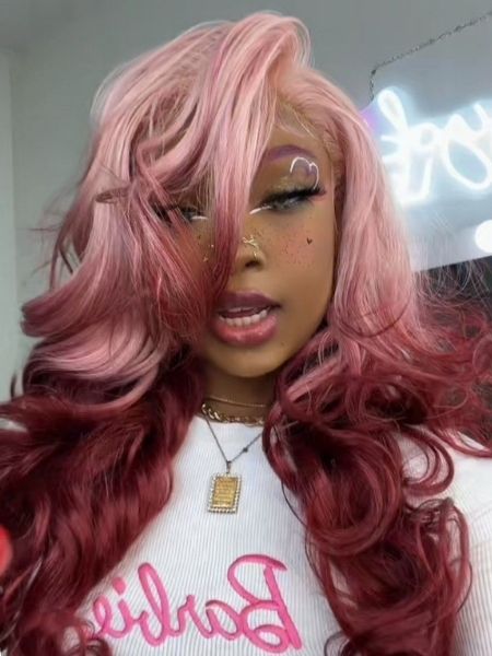 mulher de pele negra e cabelo em duas tonalidades de rosa.