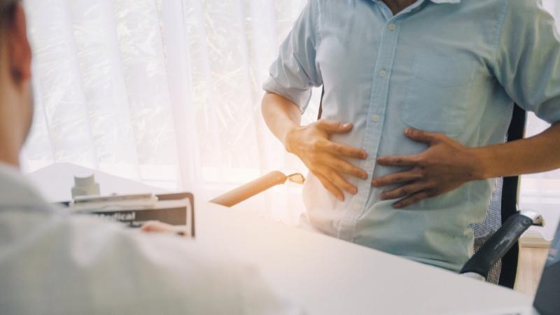 paciente com as mãos na barriga