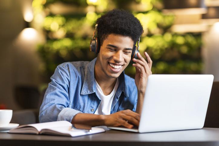 homem rindo em frente ao computador