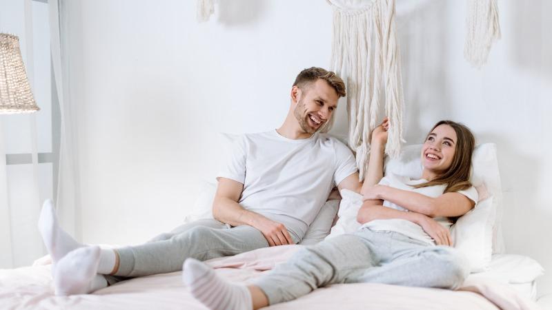 casal ri em quarto branco