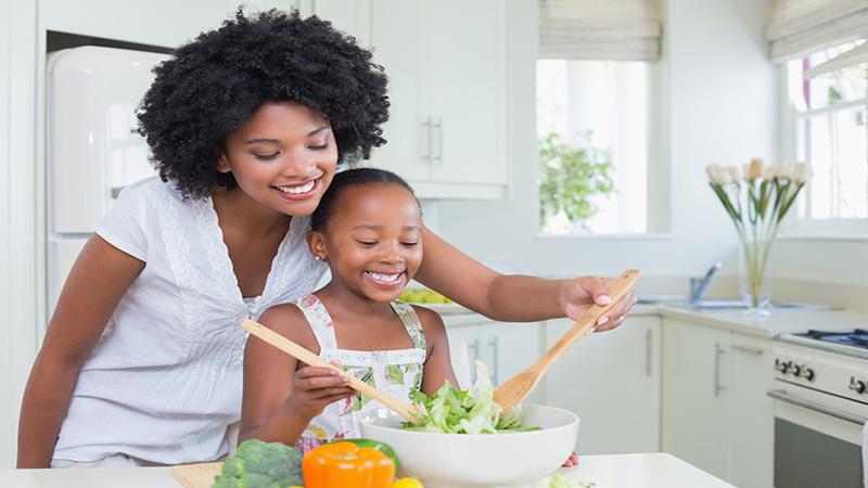 Mae e filha cozinhando