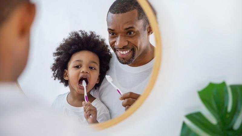 pai e filho cuidando da higiene bucal