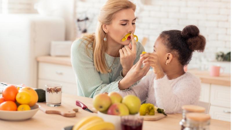 mãe e filha brincando com vegetais