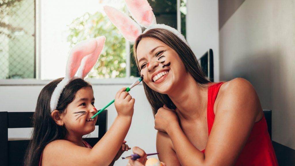 menina pintando o rosto da mãe de coelhinho da Páscoa