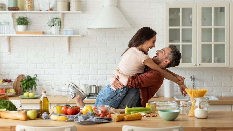 casal feliz na cozinha, cozinhando