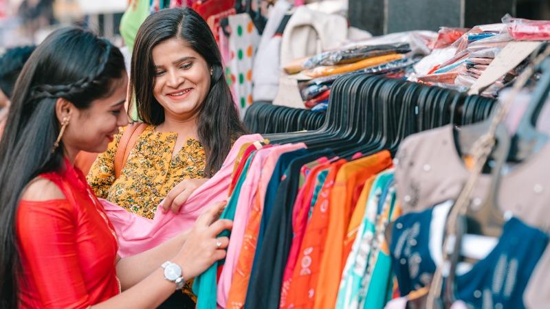 mulheres olhando roupas em loja